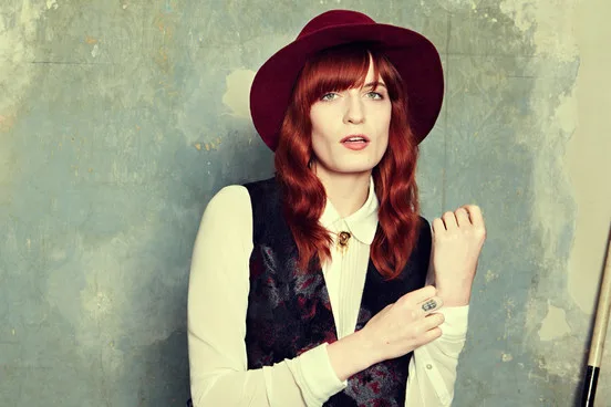 Η Florence Welch των Florence and the Machine με μπορντό καπέλο και γιλέκο.
