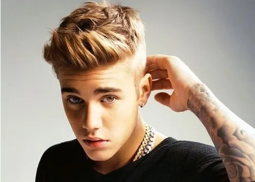 Ο Justin Bieber ποζάρει με ξανθό undercut χτένισμα και χρυσή αλυσίδα.