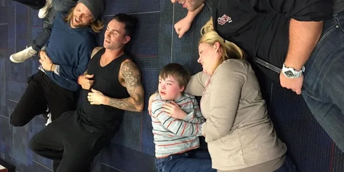 Ο Adam Levine και μέλη των Maroon 5 ξαπλωμένοι στο πάτωμα μαζί με έναν μικρό θαυμαστή.