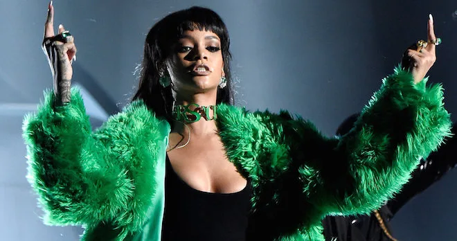 Η Rihanna με πράσινη γούνα και μαύρο φόρεμα στη σκηνή των iHeartRadio Music Awards.