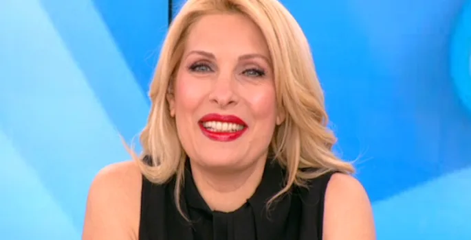 Η Ελένη Μενεγάκη χαμογελαστή σε τηλεοπτικό πλατό.