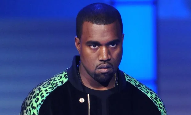 Ο Kanye West με μαύρο και πράσινο τζάκετ σε μπλε φόντο.