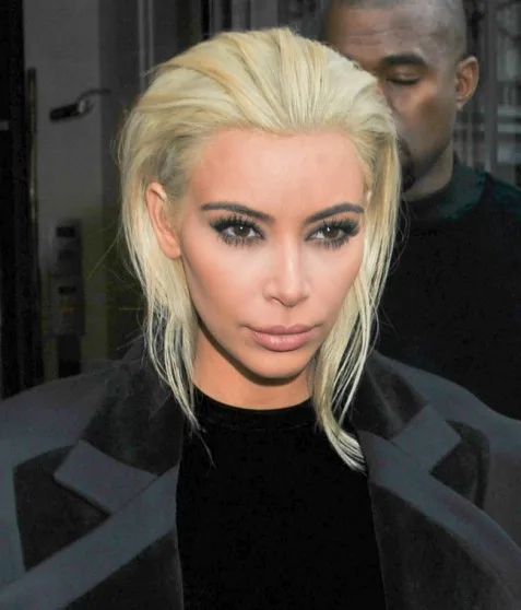 Η Kim Kardashian με πλατινέ ξανθά μαλλιά και μαύρο παλτό.