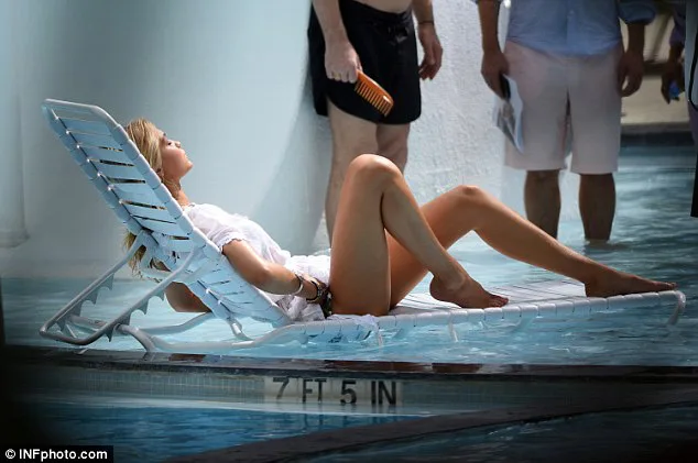 Η Gigi Hadid ξαπλωμένη σε λευκή ξαπλώστρα μέσα σε πισίνα στο Μαϊάμι.