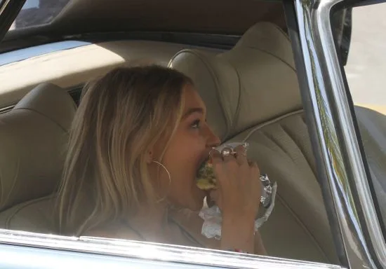 Gigi Hadid eating a Johnny Rockets Hamburguer during a break in Miami Beach