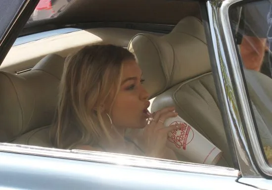 Gigi Hadid eating a Johnny Rockets Hamburguer during a break in Miami Beach