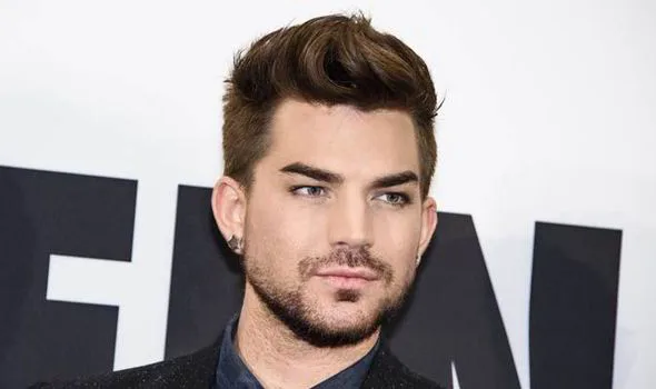 Ο Adam Lambert σε κοντινό πλάνο με καστανά μαλλιά και μούσι.