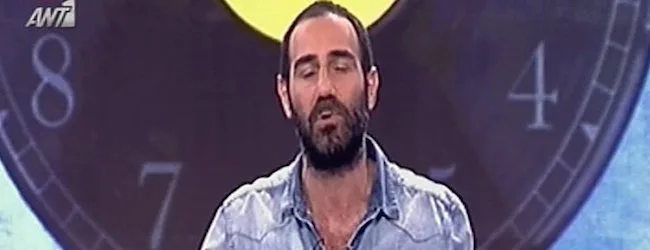 Ο Αντώνης Κανάκης σε τηλεοπτική εκπομπή με φόντο ένα μεγάλο ρολόι.