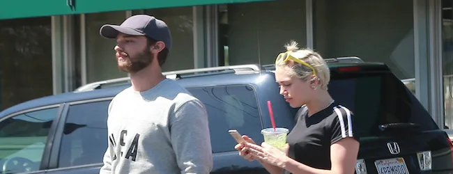 Η Miley Cyrus και ο Patrick Schwarzenegger σε εξωτερικό χώρο.