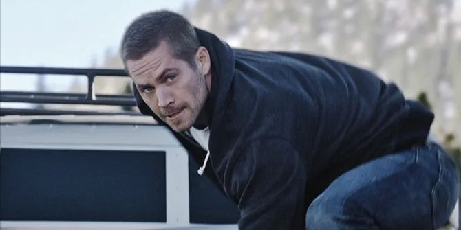 Ο Paul Walker σε σκηνή δράσης πάνω σε όχημα.