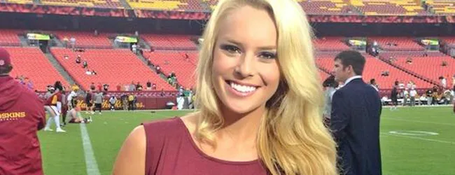 Η δημοσιογράφος Britt McHenry χαμογελά σε γήπεδο αμερικανικού ποδοσφαίρου.