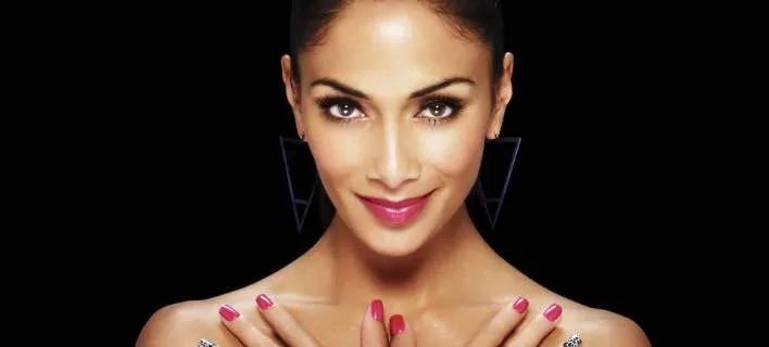 Η Nicole Scherzinger ποζάρει με τα χέρια στο στήθος και έντονο μακιγιάζ.