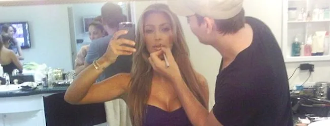 Η Kim Kardashian βγάζει selfie ενώ ένας makeup artist της βάφει τα χείλη.