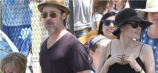 Η Angelina Jolie και ο Brad Pitt σε εξωτερικό χώρο με καπέλα και γυαλιά ηλίου.