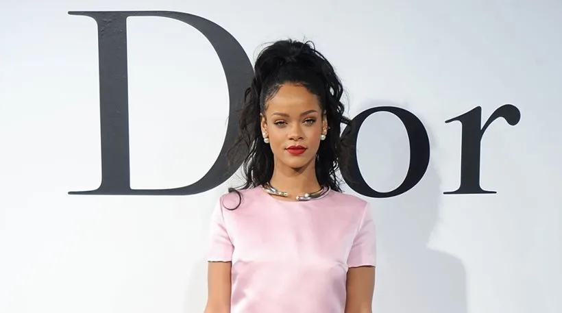 Η Rihanna ποζάρει μπροστά από το λογότυπο του οίκου Dior.