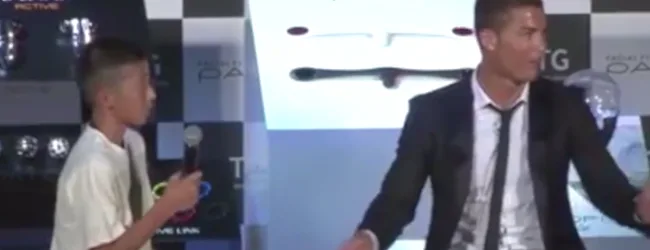Ο Κριστιάνο Ρονάλντο σε εκδήλωση στην Ιαπωνία με ένα μικρό αγόρι που κρατάει μικρόφωνο.