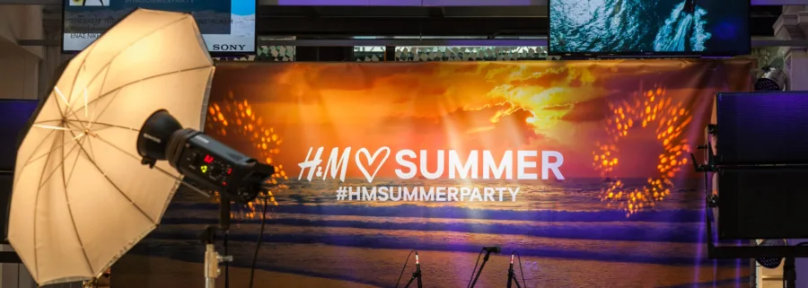 Σκηνικό για το H&M Summer Party με φόντο ηλιοβασίλεμα και εξοπλισμό φωτογράφισης.