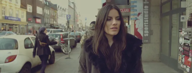 Η Phoebe Ryan περπατά σε δρόμο της πόλης.