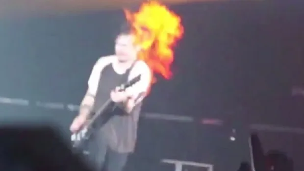 Ο Michael Clifford των 5 Seconds of Summer στη σκηνή με φλόγες στο κεφάλι του.