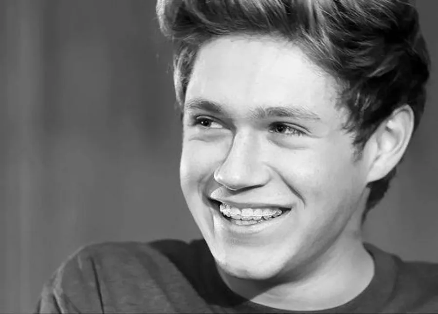 Ο Niall Horan των One Direction χαμογελάει σε ασπρόμαυρη φωτογραφία.