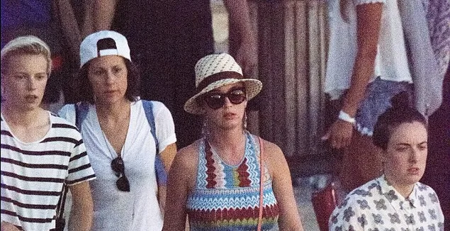 Η Katy Perry με καπέλο και γυαλιά ηλίου περπατά ανάμεσα σε κόσμο.