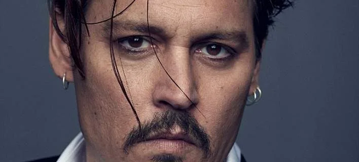 Κοντινό πορτρέτο του Johnny Depp με σκουλαρίκια κρίκους και μουστάκι.