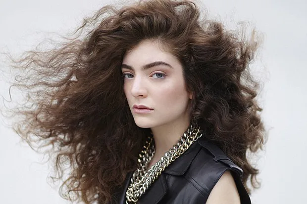 Η Lorde με πλούσια σγουρά μαλλιά και δερμάτινο γιλέκο.