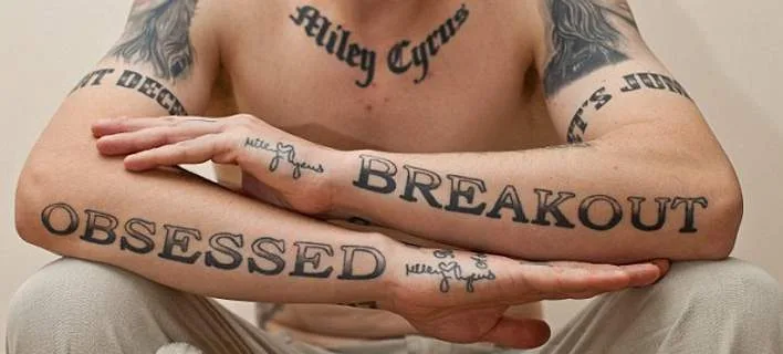 Ο Carl McCoid με τατουάζ αφιερωμένα στη Miley Cyrus στα χέρια και το στήθος.