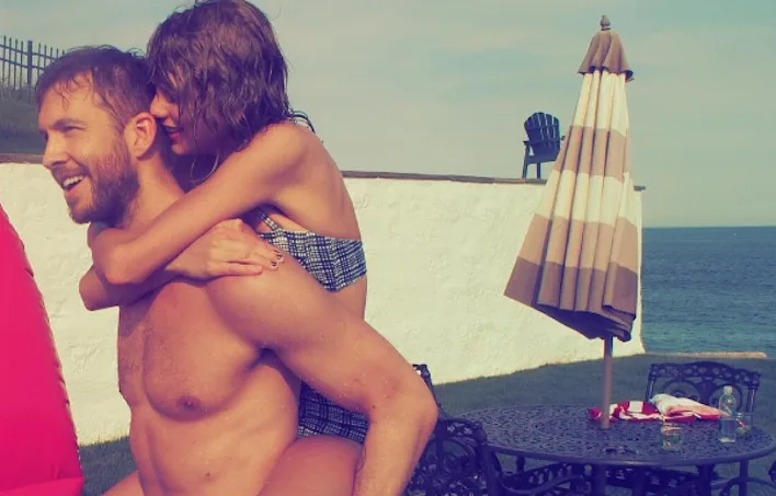 Ο Calvin Harris κουβαλάει στην πλάτη του την Taylor Swift σε εξωτερικό χώρο.