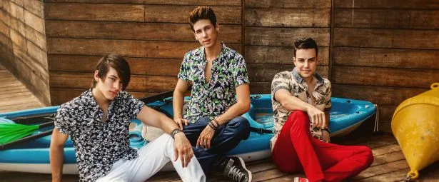 Το συγκρότημα Boys and Noise ποζάρει μπροστά από ένα μπλε καγιάκ.