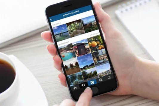 Χρήστης κρατάει smartphone με την εφαρμογή Instagram στην οθόνη.