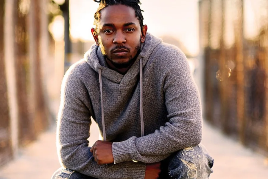Ο Kendrick Lamar με γκρι φούτερ και πλεξούδες.