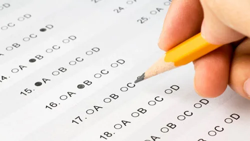 Hand completing a multiple choice exam.