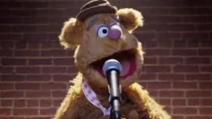 Ο Fozzie Bear από τα Muppets μπροστά από ένα μικρόφωνο.