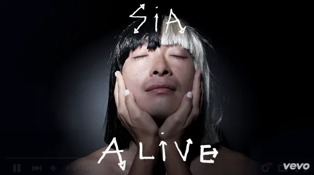 Εξώφυλλο του single Alive της Sia με ένα πρόσωπο που φοράει δίχρωμη περούκα.