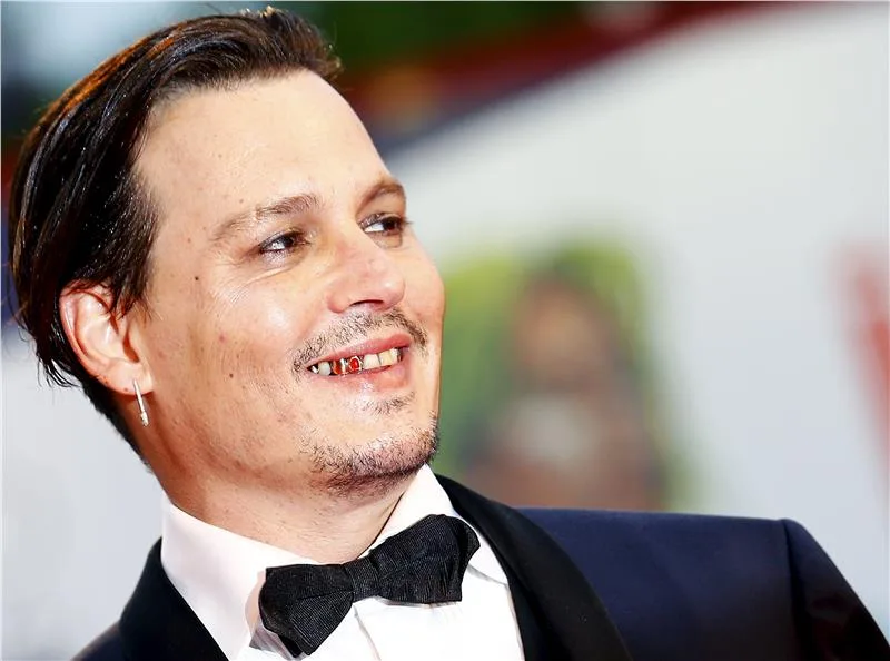Ο Johnny Depp χαμογελάει στο κόκκινο χαλί του Φεστιβάλ Βενετίας.