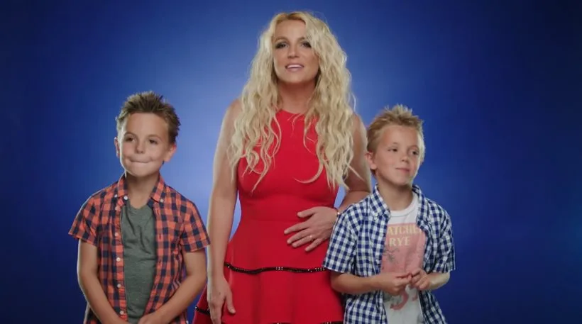 Η Britney Spears με τους δύο γιους της σε μπλε φόντο.