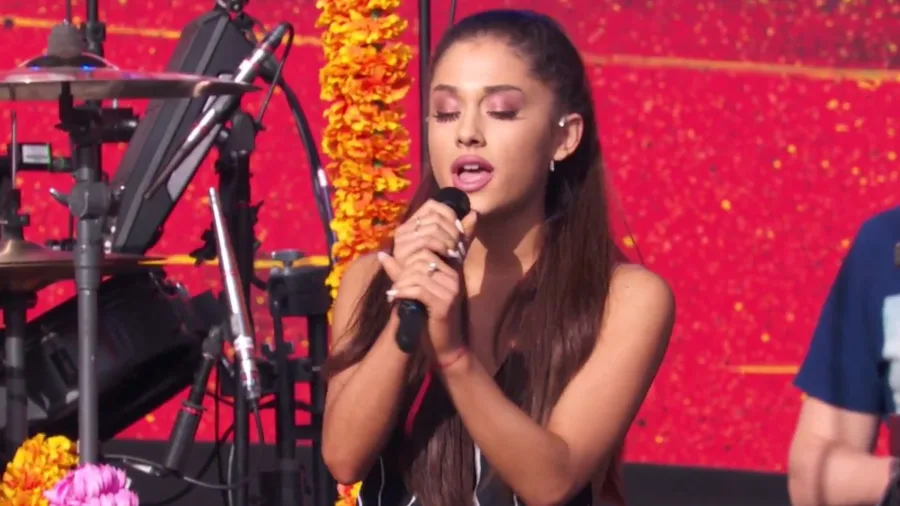 Η Ariana Grande τραγουδάει σε σκηνή με μικρόφωνο.