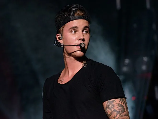 Ο Justin Bieber σε συναυλία με μαύρο καπέλο και μικρόφωνο κεφαλής.