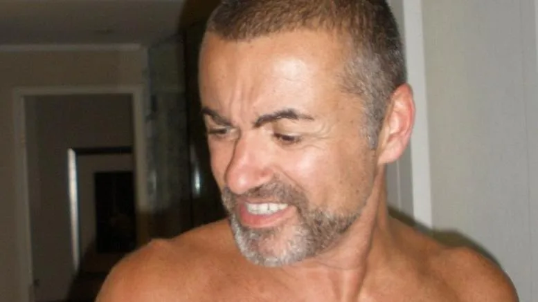 Κοντινό πλάνο του George Michael με κοντά μαλλιά και γένια.
