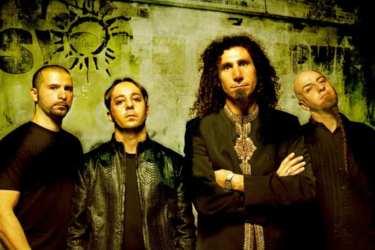 Το συγκρότημα System of A Down ποζάρει μπροστά από έναν τοίχο με γκράφιτι.