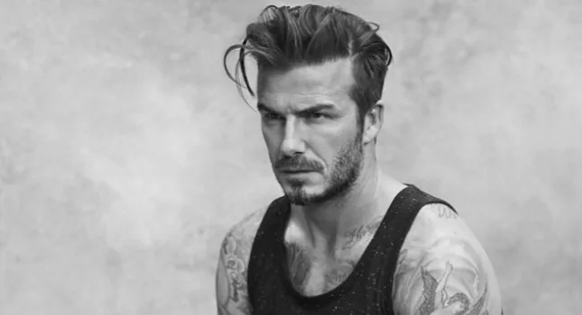 Ασπρόμαυρο πορτρέτο του David Beckham με αμάνικη μπλούζα και τατουάζ.