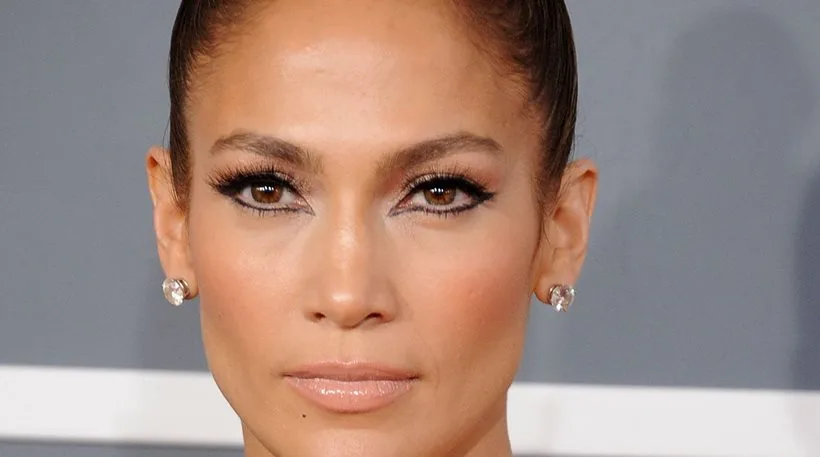 Κοντινό πλάνο της Jennifer Lopez με έντονο μακιγιάζ στα μάτια και σκουλαρίκια.
