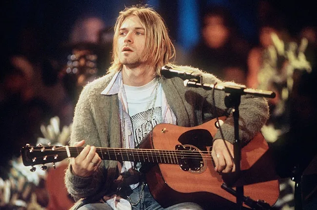 Ο Kurt Cobain παίζει ακουστική κιθάρα στη σκηνή του MTV Unplugged.