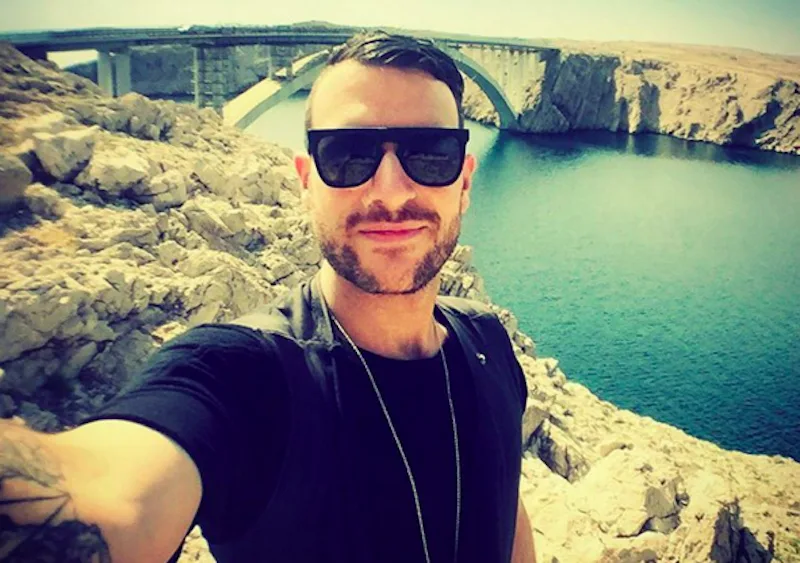 Ο Don Diablo βγάζει selfie με φόντο μια γέφυρα και τη θάλασσα.