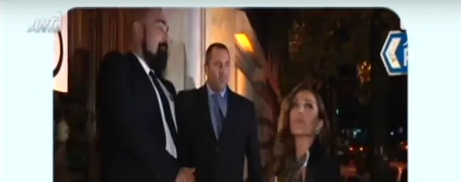 Η Δέσποινα Βανδή σε είσοδο κτιρίου με δύο άνδρες με κοστούμια.