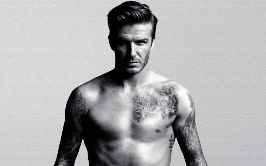 Ασπρόμαυρη φωτογραφία του David Beckham χωρίς μπλούζα, που αναδεικνύει τα τατουάζ του.