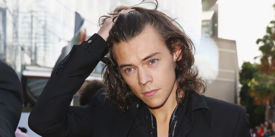 Ο Harry Styles με μακριά μαλλιά πιάνει το κεφάλι του