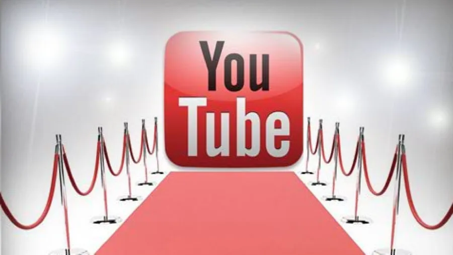 Το λογότυπο του YouTube σε κόκκινο χαλί με προβολείς