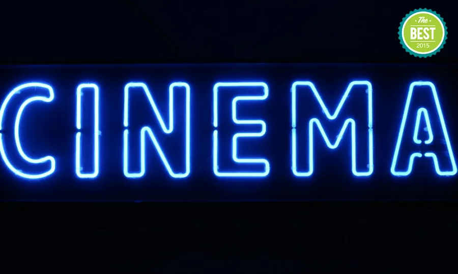 Μπλε επιγραφή νέον με τη λέξη CINEMA σε μαύρο φόντο.